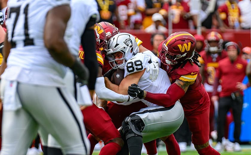 Brock Bowers being tackled by multiple Commanders. Sept. 21, 2025 — Raiders at Commanders